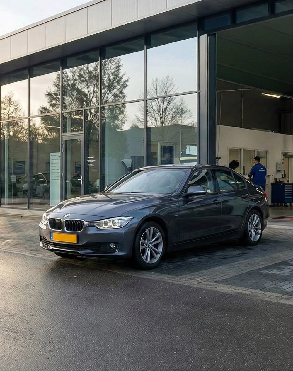 BMW geparkeerd voor garage tijdens BMW APK keuring