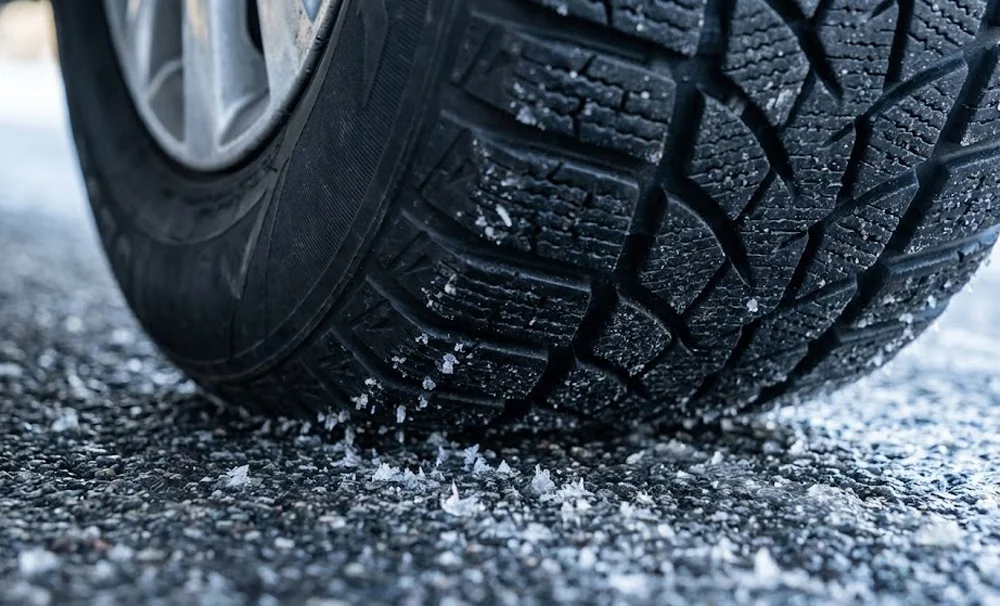 Close-up van winterband met sneeuwvlokken op het loopvlak tijdens banden wisselen