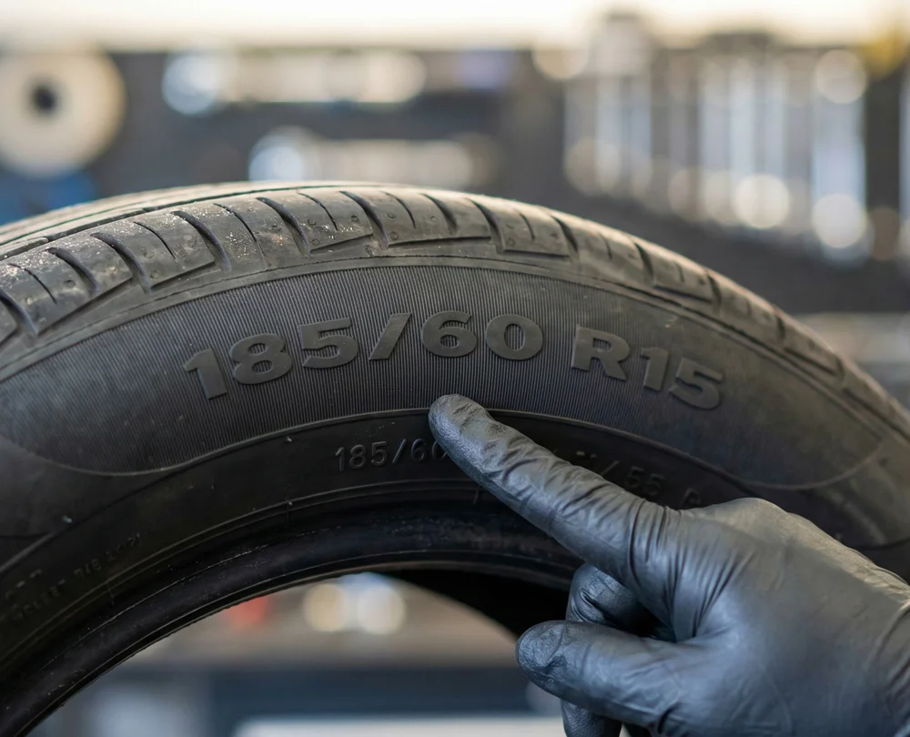 Close-up van een autoband met bandenmaat 185 60 R15 in een professionele werkplaats
