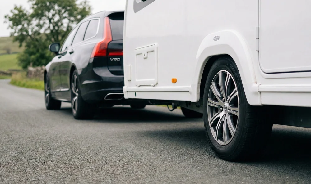 Auto trekt een caravan met goed onderhouden caravan- en camperbanden op de weg